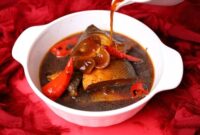 Hidangan sanga yang memikat dengan kuah kental berwarna kuning keemasan, menunjukkan kekayaan rempah alami yang digunakan dalam proses memasaknya. Potongan ikan segar tampak meresap sempurna dalam bumbu, siap memanjakan lidah setiap penikmatnya.