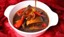 Hidangan sanga yang memikat dengan kuah kental berwarna kuning keemasan, menunjukkan kekayaan rempah alami yang digunakan dalam proses memasaknya. Potongan ikan segar tampak meresap sempurna dalam bumbu, siap memanjakan lidah setiap penikmatnya.