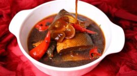 Hidangan sanga yang memikat dengan kuah kental berwarna kuning keemasan, menunjukkan kekayaan rempah alami yang digunakan dalam proses memasaknya. Potongan ikan segar tampak meresap sempurna dalam bumbu, siap memanjakan lidah setiap penikmatnya.