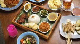Sepiring nasi kuning tumpeng lengkap dengan aneka lauk pauk tradisional Indonesia yang menggugah selera, menampilkan kekayaan rempah dan filosofi budaya dalam setiap sajian. Hidangan ini seringkali menjadi pusat perhatian dalam berbagai acara syukuran dan perayaan penting di seluruh Nusantara.