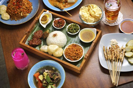 Sepiring nasi kuning tumpeng lengkap dengan aneka lauk pauk tradisional Indonesia yang menggugah selera, menampilkan kekayaan rempah dan filosofi budaya dalam setiap sajian. Hidangan ini seringkali menjadi pusat perhatian dalam berbagai acara syukuran dan perayaan penting di seluruh Nusantara.