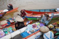 Pemandangan dari udara menunjukkan kelokan megah Sungai Mahakam yang membelah hutan hijau Kalimantan Timur, memperlihatkan betapa luas dan vitalnya aliran sungai ini bagi lanskap sekitarnya. Perahu-perahu kecil tampak bergerak perlahan, menjadi saksi bisu denyut kehidupan di salah satu sungai terpanjang di Indonesia.