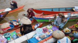 Pemandangan dari udara menunjukkan kelokan megah Sungai Mahakam yang membelah hutan hijau Kalimantan Timur, memperlihatkan betapa luas dan vitalnya aliran sungai ini bagi lanskap sekitarnya. Perahu-perahu kecil tampak bergerak perlahan, menjadi saksi bisu denyut kehidupan di salah satu sungai terpanjang di Indonesia.