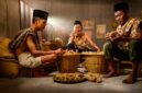 Seorang balian Dayak sedang menunjukkan berbagai jenis tanaman obat yang tumbuh subur di hutan Kalimantan, mencerminkan kekayaan alam yang menjadi sumber pengobatan tradisional mereka selama berabad-abad. Ramuan-ramuan ini menjadi simbol kearifan lokal yang dijaga turun-temurun.