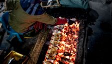 Pemandangan otentik biji kopi Lombok sedang disangrai di atas bara arang kelapa, sebuah metode tradisional yang memberikan Sanga aroma khas dan rasa unik. Proses ini menunjukkan kearifan lokal dalam mengolah kopi secara manual.