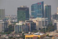 Pemandangan kota Jakarta yang sibuk dengan gedung-gedung pencakar langit, merefleksikan hiruk pikuk kehidupan urban yang menuntut adaptasi dan strategi keseimbangan dari para penghuninya. Setiap sudut kota ini menyimpan cerita tentang perjuangan dan resiliensi individu dalam menghadapi dinamika modern.