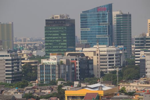 Pemandangan kota Jakarta yang sibuk dengan gedung-gedung pencakar langit, merefleksikan hiruk pikuk kehidupan urban yang menuntut adaptasi dan strategi keseimbangan dari para penghuninya. Setiap sudut kota ini menyimpan cerita tentang perjuangan dan resiliensi individu dalam menghadapi dinamika modern.