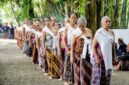 Seorang Belian, pemimpin ritual adat suku Dayak Benuaq, mengenakan pakaian tradisional lengkap saat memimpin upacara Belian yang sakral di Kalimantan Timur. Pakaian dan aksesori ini memiliki makna simbolis yang mendalam dalam setiap tahapan ritual penyembuhan.