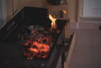 Seorang ibu sedang menyangrai biji kopi robusta di atas tungku arang tradisional, sebuah pemandangan umum yang menunjukkan proses pembuatan kopi sanga di Lombok. Teknik penyangraian manual ini menjadi kunci utama untuk menghasilkan aroma dan cita rasa khas yang membedakan kopi sanga dari kopi modern lainnya.