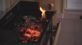 Seorang ibu sedang menyangrai biji kopi robusta di atas tungku arang tradisional, sebuah pemandangan umum yang menunjukkan proses pembuatan kopi sanga di Lombok. Teknik penyangraian manual ini menjadi kunci utama untuk menghasilkan aroma dan cita rasa khas yang membedakan kopi sanga dari kopi modern lainnya.