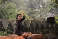 Seorang model berpose anggun mengenakan busana modern dengan motif batik khas Kalimantan Timur, menunjukkan perpaduan harmonis antara tradisi dan tren terkini. Pakaian ini mencerminkan bagaimana kekayaan budaya lokal kini diadaptasi menjadi gaya hidup urban yang elegan dan berkelas.