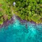 Pemandangan udara Kepulauan Derawan menunjukkan air laut biru kehijauan yang jernih dengan pulau-pulau kecil berpasir putih. Foto ini menangkap keindahan panorama gugusan pulau eksotis yang kaya akan kehidupan bawah laut.