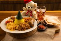 Sepiring nasi kuning hangat dengan beragam lauk pauk seperti ayam goreng, telur iris, dan serundeng, siap memanjakan lidah para penikmat kuliner. Hidangan ikonik ini mencerminkan kekayaan budaya dan tradisi kuliner Indonesia yang tak lekang oleh waktu.
