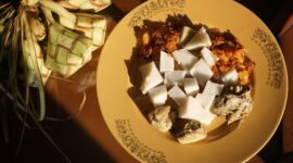 Semangkuk sanga hangat disajikan dengan taburan kelapa sangrai, menampilkan tekstur lembut dan aroma khas yang mengundang selera, sebuah representasi kelezatan kuliner tradisional Indonesia Timur.