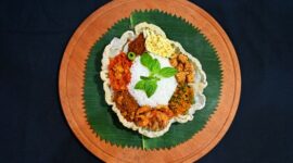 Sajian tumpeng nasi kuning yang ikonik dengan aneka lauk pauk tradisional, melambangkan syukur dan kemakmuran dalam berbagai perayaan di Indonesia. Hidangan ini memancarkan kehangatan dan kekayaan budaya kuliner Nusantara.