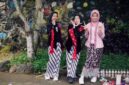 Seorang model berpose anggun mengenakan busana batik Kalimantan Timur dengan motif kontemporer, menunjukkan bagaimana warisan budaya dapat diinterpretasikan ulang menjadi tren mode yang relevan. Perpaduan warna cerah dan desain modern ini berhasil menarik perhatian pasar fashion global, membuktikan fleksibilitas batik dalam berbagai gaya.