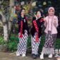 Seorang model berpose anggun mengenakan busana batik Kalimantan Timur dengan motif kontemporer, menunjukkan bagaimana warisan budaya dapat diinterpretasikan ulang menjadi tren mode yang relevan. Perpaduan warna cerah dan desain modern ini berhasil menarik perhatian pasar fashion global, membuktikan fleksibilitas batik dalam berbagai gaya.