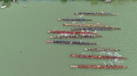 Pemandangan matahari terbenam di Sungai Mahakam, menampilkan perahu tradisional yang berlayar tenang di atas air, mencerminkan kehidupan damai masyarakat lokal yang bergantung pada sungai ini. Latar belakang hutan lebat di tepian sungai menunjukkan kekayaan alam Kalimantan Timur yang perlu terus dijaga.