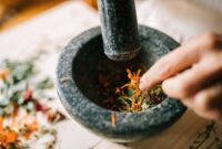Seorang ahli pengobatan tradisional di Kutai sedang menyiapkan ramuan herbal dari berbagai jenis akar dan dedaunan khas Kalimantan, menunjukkan kekayaan kearifan lokal dalam meracik obat alami. Proses peracikan ini menjadi bagian tak terpisahkan dari budaya masyarakat Kutai dalam menjaga kesehatan tubuh secara turun-temurun.