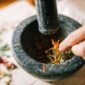Seorang ahli pengobatan tradisional di Kutai sedang menyiapkan ramuan herbal dari berbagai jenis akar dan dedaunan khas Kalimantan, menunjukkan kekayaan kearifan lokal dalam meracik obat alami. Proses peracikan ini menjadi bagian tak terpisahkan dari budaya masyarakat Kutai dalam menjaga kesehatan tubuh secara turun-temurun.