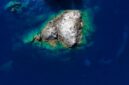 Pemandangan udara Kepulauan Derawan memperlihatkan gradasi warna biru laut yang menawan, dikelilingi oleh terumbu karang sehat dan pasir putih bersih, sebuah panorama surga bahari. Keindahan ini merupakan magnet utama bagi wisatawan yang mencari pengalaman menyelam dan bersnorkeling kelas dunia.