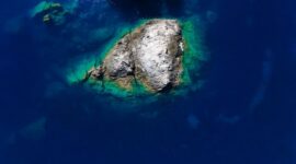 Pemandangan udara Kepulauan Derawan memperlihatkan gradasi warna biru laut yang menawan, dikelilingi oleh terumbu karang sehat dan pasir putih bersih, sebuah panorama surga bahari. Keindahan ini merupakan magnet utama bagi wisatawan yang mencari pengalaman menyelam dan bersnorkeling kelas dunia.