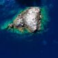 Pemandangan udara Kepulauan Derawan memperlihatkan gradasi warna biru laut yang menawan, dikelilingi oleh terumbu karang sehat dan pasir putih bersih, sebuah panorama surga bahari. Keindahan ini merupakan magnet utama bagi wisatawan yang mencari pengalaman menyelam dan bersnorkeling kelas dunia.