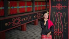 Seorang model berpose mengenakan busana modern dengan motif batik Dayak yang khas dari Kalimantan Timur, menunjukkan perpaduan harmonis antara tradisi dan gaya kontemporer yang memukau. Pakaian ini mencerminkan inovasi desain yang membawa kekayaan budaya lokal ke panggung mode global.