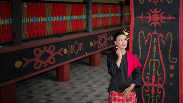 Seorang model berpose mengenakan busana modern dengan motif batik Dayak yang khas dari Kalimantan Timur, menunjukkan perpaduan harmonis antara tradisi dan gaya kontemporer yang memukau. Pakaian ini mencerminkan inovasi desain yang membawa kekayaan budaya lokal ke panggung mode global.