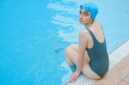 Seorang wanita menikmati sesi aqua aerobik di kolam renang, menunjukkan bagaimana olahraga air dapat menjadi pilihan kebugaran yang menyenangkan dan efektif untuk berbagai usia. Gerakan dalam air membantu mengurangi tekanan pada sendi, menjadikannya ideal untuk latihan intensitas tinggi namun rendah risiko cedera.