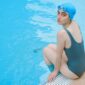 Seorang wanita menikmati sesi aqua aerobik di kolam renang, menunjukkan bagaimana olahraga air dapat menjadi pilihan kebugaran yang menyenangkan dan efektif untuk berbagai usia. Gerakan dalam air membantu mengurangi tekanan pada sendi, menjadikannya ideal untuk latihan intensitas tinggi namun rendah risiko cedera.