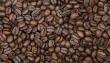 Seorang wanita tengah menyangrai biji kopi robusta yang telah dicampur parutan kelapa segar di atas bara api, sebuah proses penting dalam pembuatan kopi sanga tradisional khas Lombok. Pemandangan ini merefleksikan kearifan lokal dalam mengolah kekayaan alam menjadi minuman yang penuh cita rasa.