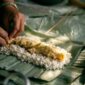 Sanga, nasi bakar khas Kalimantan yang dibungkus daun pisang dan dipanggang di atas bara api, menampilkan keunikan kuliner tradisional dengan aroma smoky yang memikat selera. Hidangan ini seringkali berisi ayam suwir atau ikan teri pedas.