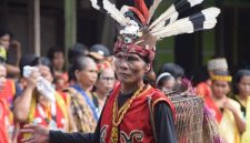 Wanita Suku Dayak Kenyah dengan telinga panjang khas yang dihiasi anting-anting tradisional, menunjukkan keunikan budaya dan keindahan warisan leluhur mereka. Tampilan ini adalah bagian tak terpisahkan dari identitas dan status sosial di tengah masyarakat adat.