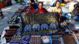 Seorang model mengenakan busana dengan motif batik khas Kalimantan Timur yang menampilkan pola Burung Enggang, menunjukkan perpaduan harmonis antara tradisi dan tren fesyen kontemporer. Kain ini mencerminkan kekayaan budaya Borneo yang disajikan dalam balutan modern.