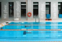 Seorang wanita sedang berenang santai di kolam renang yang jernih, merasakan kebebasan bergerak di dalam air yang menenangkan. Olahraga air bukan hanya menyegarkan fisik, tapi juga memberikan efek relaksasi yang mendalam bagi pikiran.
